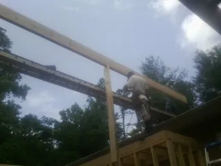 Carpenter setting a ridge beam over a new addition frame — Ice Dam Removal by Roofing Brothers in Deer Grove