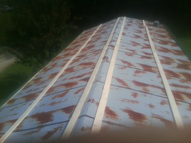 Rusted metal roof panels with new wood purlins before replacement — Storm Damage Roof Repair in Deer Grove by Roofing Brothers