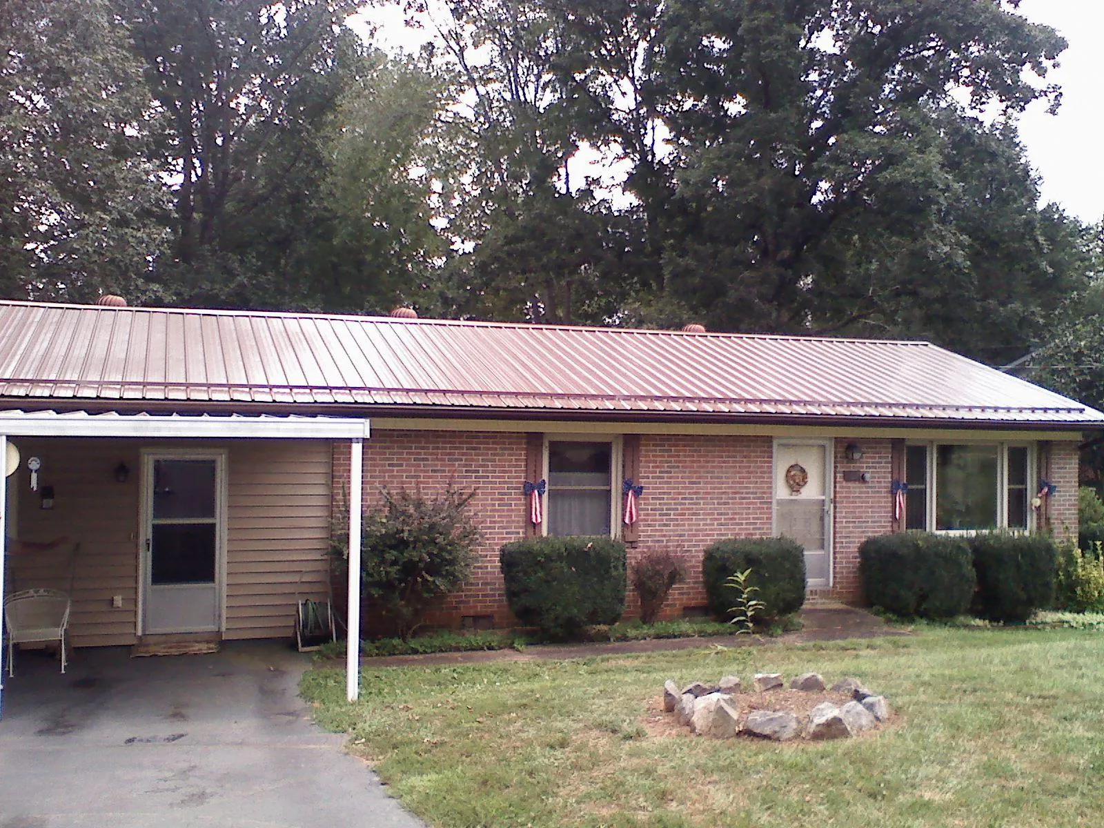 Bronze metal roof and carport on a brick ranch home — Roof Repair work by our crew in Deer Grove